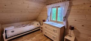 a bedroom with a bed and a window in a log cabin at Domek myśliwski w górach in Ujsoły