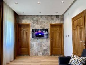 uma sala de estar com televisão numa parede de pedra em Blue Star Apartments em Ulcinj
