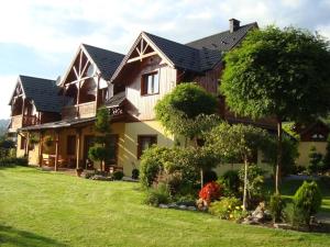 duży dom z zielonym trawnikiem przed nim w obiekcie Osada turystyczna Malinów w mieście Szczawnica