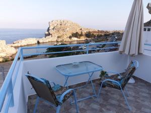 a table and two chairs on a balcony with the ocean at St Paul's Studios Chrysanthi in Líndos