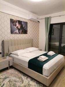 ein Schlafzimmer mit einem Bett und einem Fernseher an der Wand in der Unterkunft ZIGON Summer Place by Casa Del Mar in Mamaia