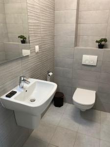 ein Badezimmer mit einem weißen Waschbecken und einer Toilette in der Unterkunft ZIGON Summer Place by Casa Del Mar in Mamaia