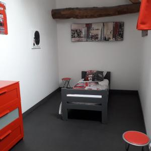 ein kleines Schlafzimmer mit einem Bett und einer roten Kommode in der Unterkunft grange dans ancien corps de ferme in Bellengreville