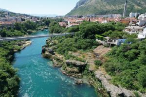 eine Brücke über einen Fluss neben einer Stadt in der Unterkunft Apartman Dva mosta in Mostar