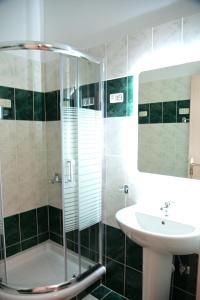 bagno con doccia in vetro e lavandino di BIG BLUE HOTEL a Amaliápoli