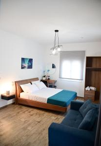 a bedroom with a bed and a blue couch at BIG BLUE HOTEL in Amaliápoli