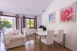 sala de estar con mesa y sillas blancas en Villa Julieta 454, en Crestatx
