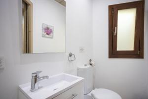 a bathroom with a sink and a toilet and a mirror at Casa Pequeña in Crestatx +12 photos
