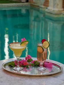 two cocktails on a tray next to a pool at El Palacito Secreto Luxury Boutique Hotel & Spa in Mérida +38 photos