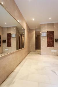 baño grande con espejos y suelo de baldosa. en Torreluz Apartamentos, en Almería