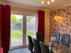 a dining room with a table and chairs and a window at Exclusive Homely Cambridge 4 bed house with free parking, big garden and sleeps 10 in Cambridge