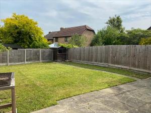 a backyard with a fence and a yard at Exclusive, Homely & Warm Cambridge 4 bed house with free parking, garden and sleeps 10 in Cambridge