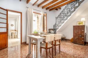 a dining room with a table and chairs and a staircase at Ca na Francesca in Pollença