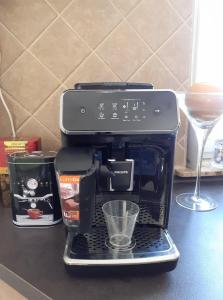 eine Kaffeemaschine auf einer Theke mit einem Glas in der Unterkunft Apartament Meluzyna in Puck