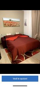a bedroom with a large bed with a red bedspread at Appartamento “La Corte” in Paderno Dugnano