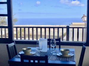 tavolo con sedie e bicchieri e vista sull'oceano di Las Casitas Rusticas a La Asomada