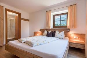 una camera da letto con un grande letto bianco e una finestra di App Sonnenblume Biohof Unterspisser a Laion