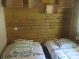 two beds in a small room with wooden walls at Mas Torrenaps in Argelès-sur-Mer