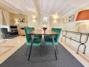 a dining room with a table and green chairs at Lisbon Cottage Principe Real in Lisbon