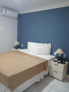 ein Schlafzimmer mit 2 Betten und einer blauen Wand in der Unterkunft Flat Ponta Negra Beach - Ap 401 in Natal