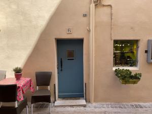 a blue door of a building with a table and chairs at appartement du pêcheur à Cassis à 10 mètres du port in Cassis
