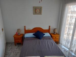 a bedroom with a bed with two night stands and two windows at Fuensanta 400m to Beach Med Syndicate 10 in Torrevieja