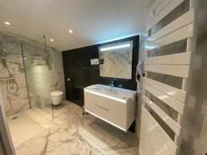 a bathroom with a sink and a glass shower at Hotel Restaurant Lesage in Sarzeau