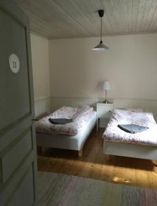 ein Schlafzimmer mit 2 Betten und einer Lampe in der Unterkunft Hallagårdens B&B in Vintrosa