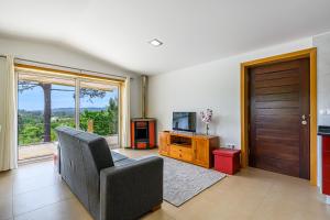a living room with a couch and a tv and a door at Escolinha de France in France