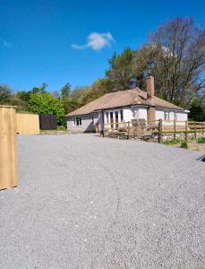 a house with a fence and a gravel driveway at 3 Bedroom Bungalow in Llanrhaeadr Ym in Oswestry