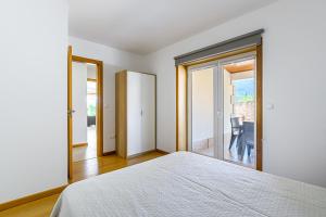a bedroom with a bed and a sliding glass door at Escolinha de France in France +9 photos