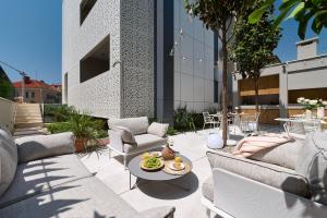 une terrasse avec des canapés, une table et des chaises dans l'établissement Luxury Apartments Villa Mala Split, à Split