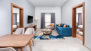 هوليداي ان تبوك في تبوك: غرفة معيشة مع أريكة زرقاء وطاولة