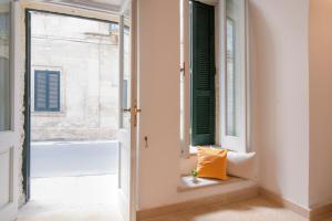 レッチェにあるBlue Loft - Lecce Selectionの窓枠に黄色の枕が付いた開放ドア
