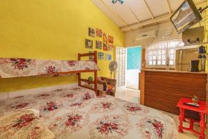 a bedroom with a bed in a room with a kitchen at Chalés Ilhabela in Ilhabela