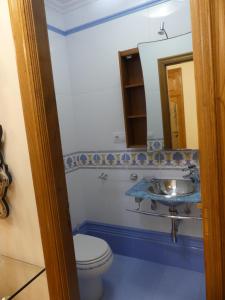 a bathroom with a toilet and a sink at Apartamentos Villa Nustre in Boiro