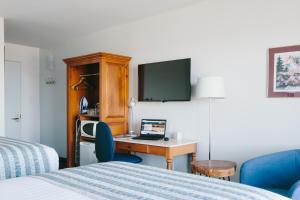 a hotel room with a desk with a laptop on it at Pavillon sur Mer par Riôtel in Matane
