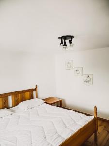ein Schlafzimmer mit einem weißen Bett mit einem Licht an der Wand in der Unterkunft Noclegi Studio Masażu in Włodawa
