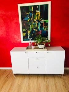 a white dresser with a painting on a red wall at Ferienwohnung Marie in Feldberg