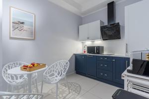 a kitchen with blue cabinets and a table and chairs at Willa Letnia in Krynica Morska
