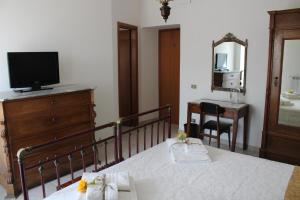 een slaapkamer met een bed en een dressoir met een televisie bij B&B Montagano in Montagano