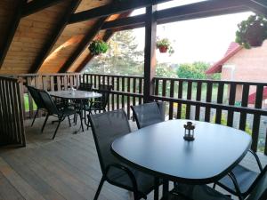 two tables and chairs on the deck of a cabin at Pokoje Gościnne Sandomingo in Sandomierz
