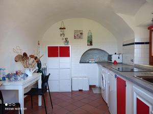 a kitchen with red and white cabinets and a table at La Quiete in Beverino