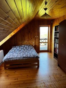 um quarto com uma cama num quarto de madeira em Skrajna Chata Chrzypsko em Chrzypsko Wielkie