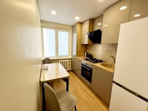 a small kitchen with a table and a sink at M&M Apartment V SELF CHECK-IN in Panevėžys