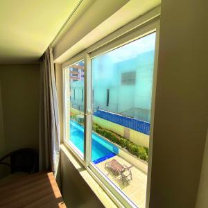a window with a view of a swimming pool at Beira Mar Imperial Flat 612 in João Pessoa