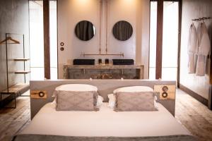 a bedroom with a bed with two pillows and mirrors at Rio do Prado in Arelho