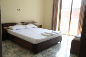 - une chambre avec un lit et une grande fenêtre dans l'établissement Shtepi Pushimi, à Durrës