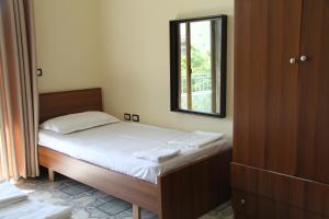 Dormitorio pequeño con cama y espejo en Shtepi Pushimi, en Durrës