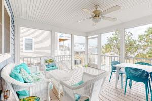 porche con sillas, mesa y ventilador de techo en Town of Bethany Beach - 222 Ocean View, en Bethany Beach